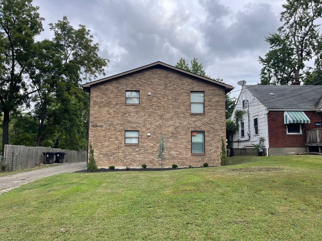 A brick house with a green lawn in front.
