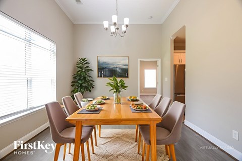A dining room with a wooden table and chairs.