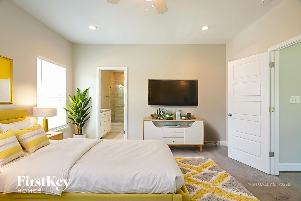 A bedroom with a bed, dresser, and television.