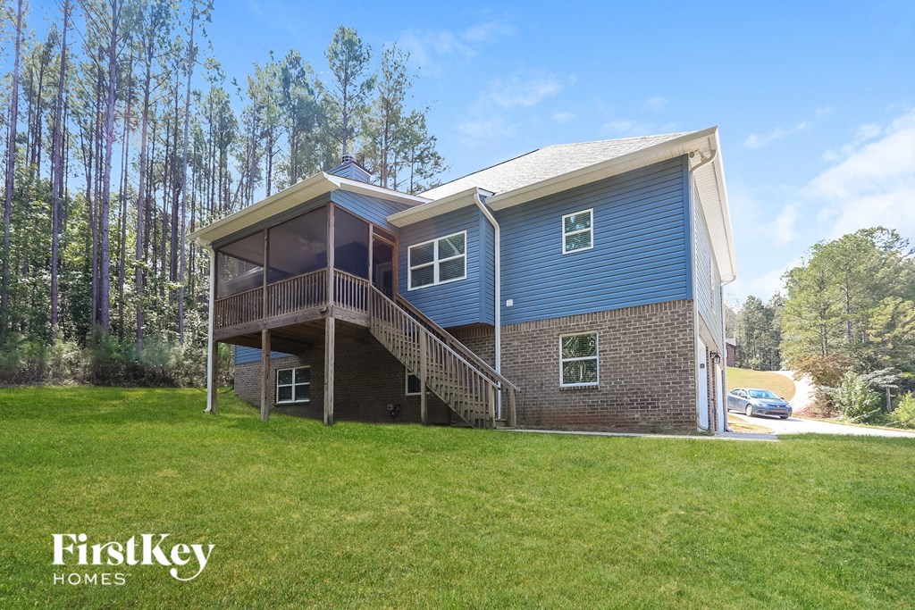 A blue house with a white roof and a balcony on the second floor.