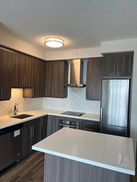 A kitchen with a white counter top and brown cabinets.
