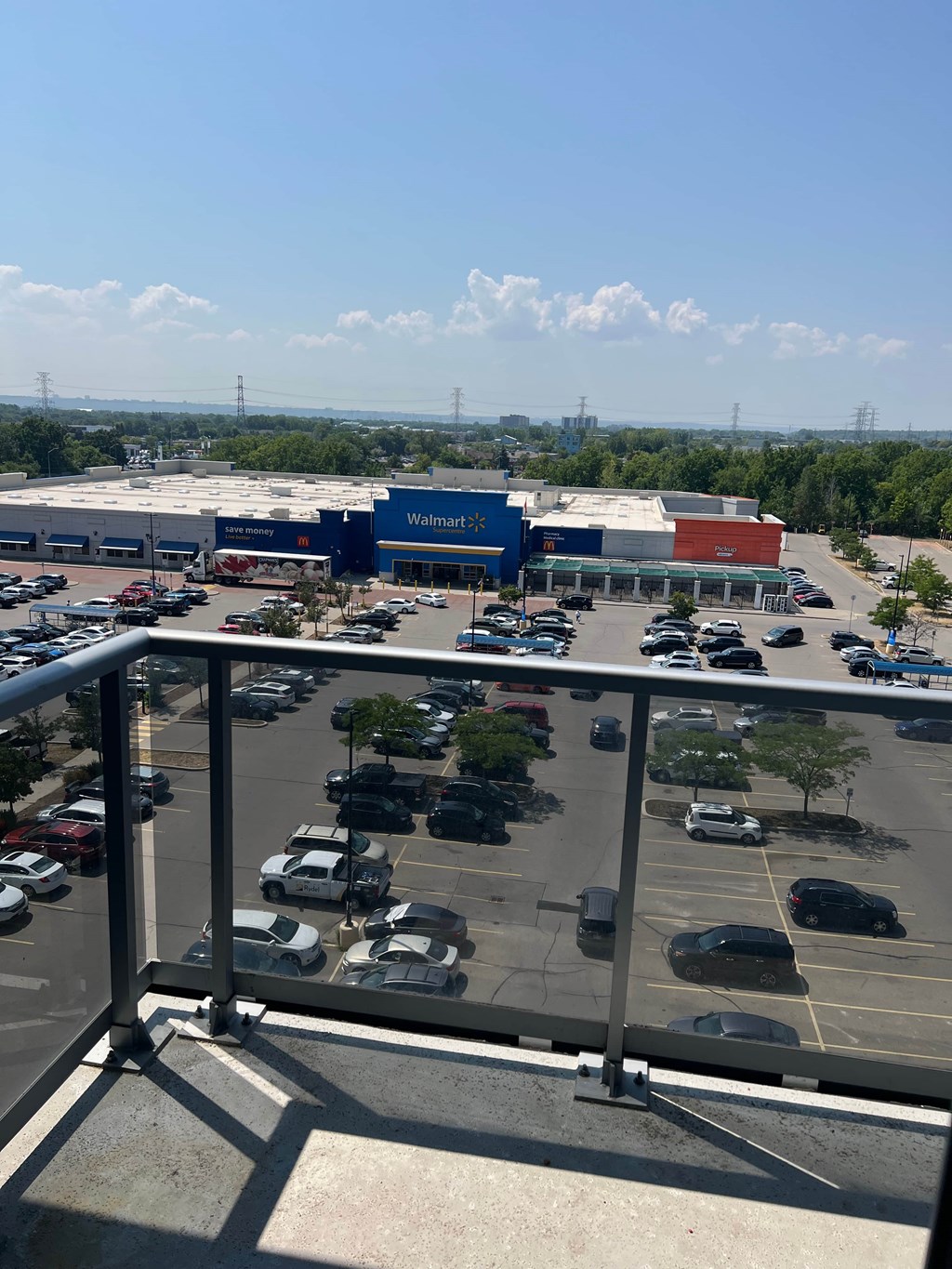 A Walmart store is seen from a balcony with a parking lot in front.