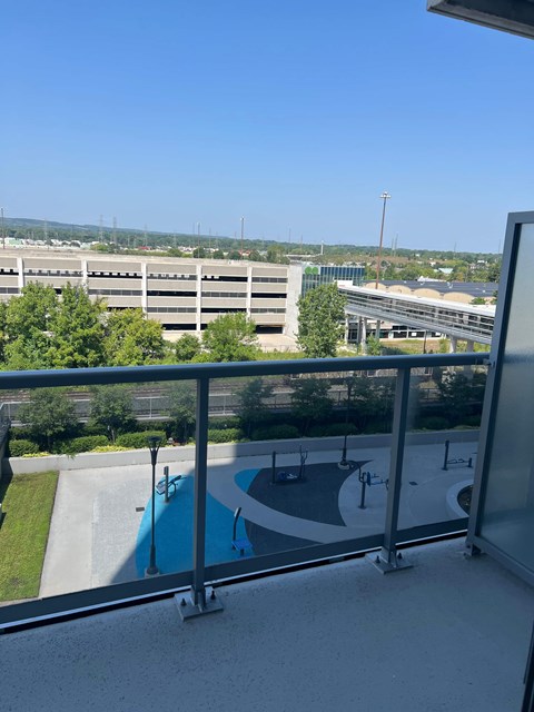 A view from a balcony overlooking a pool and a parking lot.