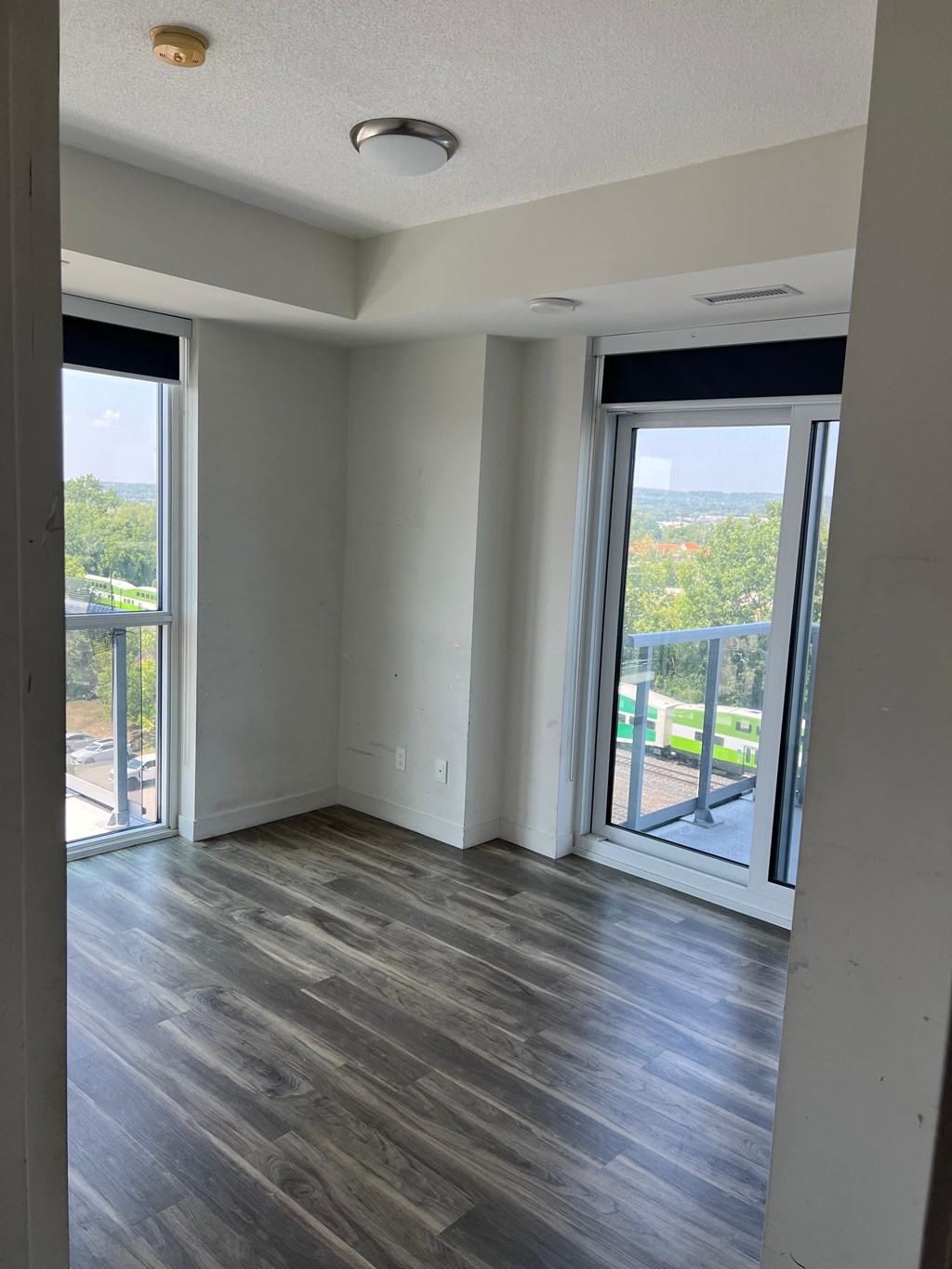 A room with a view of a parking lot through the windows.