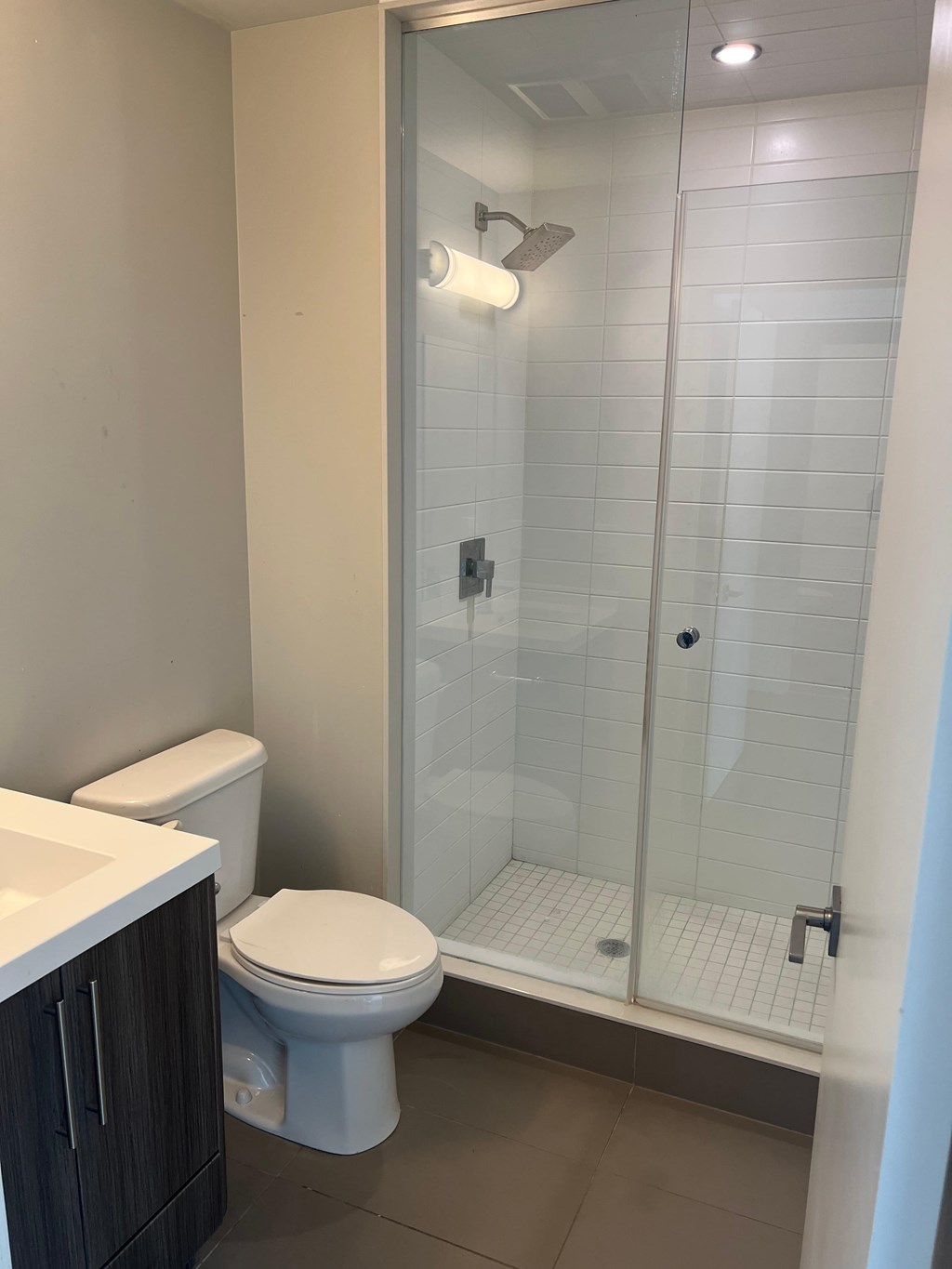 A white toilet sits next to a sink in a bathroom.