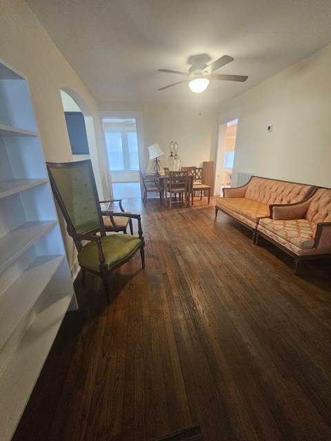 A living room with a brown couch and a green chair.