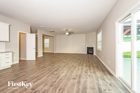 A spacious living room with wood flooring and a ceiling fan.
