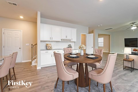 A dining room with a round table and chairs.