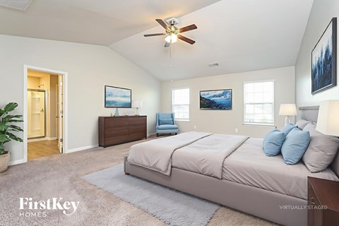 A bedroom with a bed, dresser, and ceiling fan.