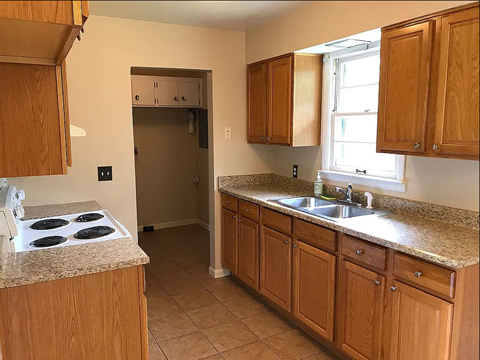 A kitchen with wooden cabinets and a granite countertop.