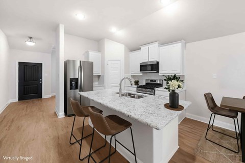 A kitchen with a white countertop and brown chairs.