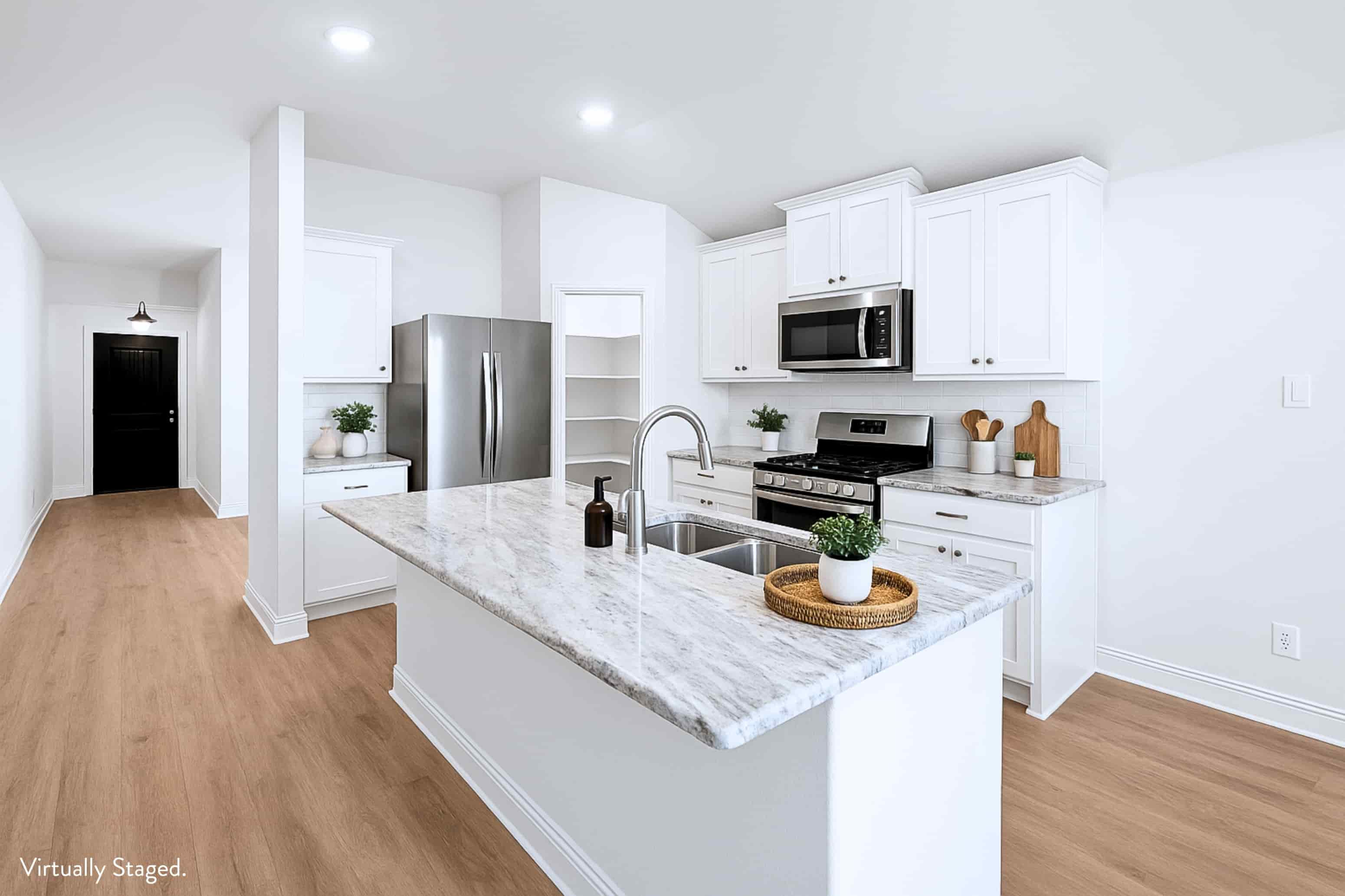 A kitchen with white cabinets and a marble countertop.
