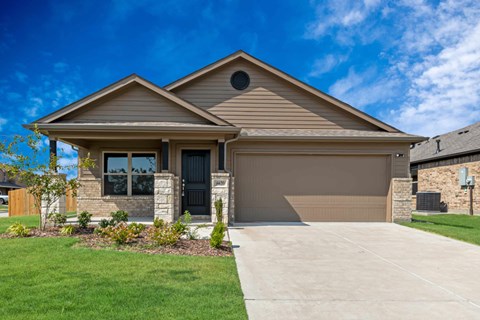 A house with a brown garage door and a stone pillar.
