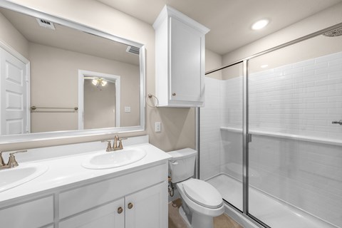 A white bathroom with a toilet, sink, and shower.