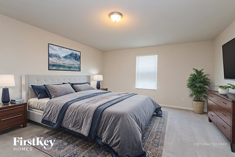 A bedroom with a large bed and a painting on the wall.