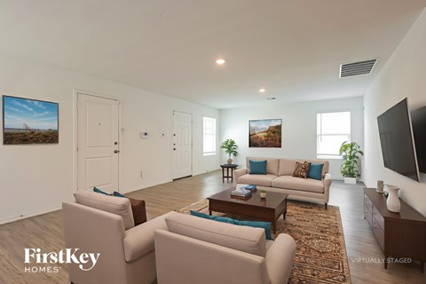 A living room with a couch, chairs, and a rug.