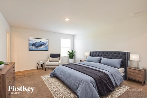 A bedroom with a large bed and a painting on the wall.