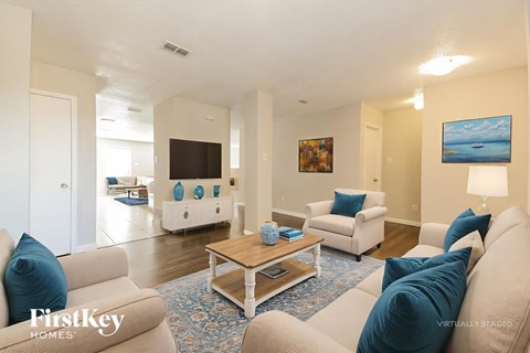 A living room with a beige couch and a coffee table.