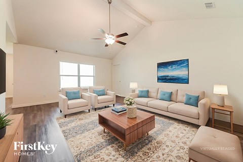 A living room with a couch, a coffee table, and a painting on the wall.