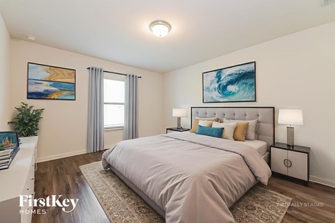 A bedroom with a large bed and a painting on the wall.