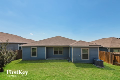 A house with a blue exterior and a brown roof is shown with the words "FirstKey Homes" on the bottom left.