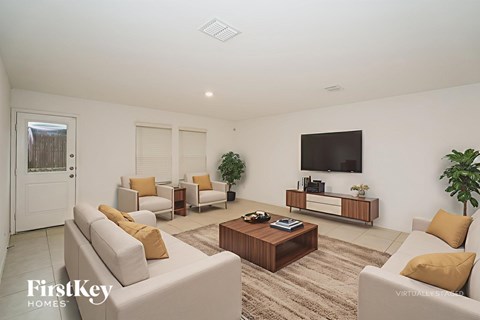 A living room with a white couch and a wooden coffee table.