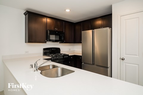 A kitchen with a stainless steel refrigerator and a white countertop.