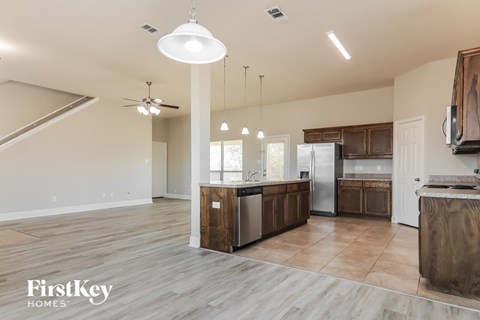 A kitchen with wooden cabinets and a stainless steel refrigerator.