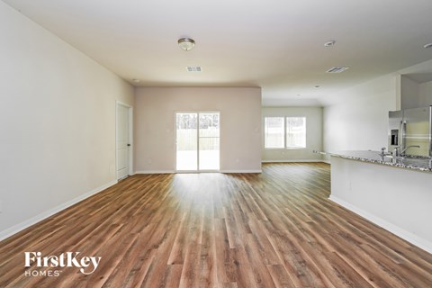 A spacious room with wooden floors and a large window.