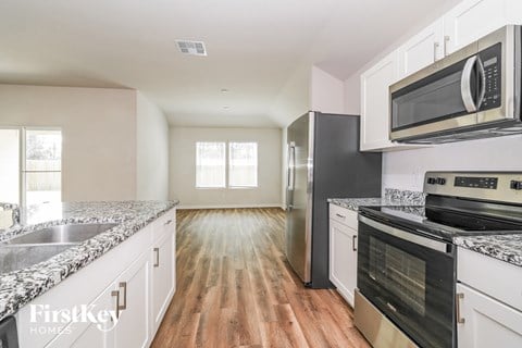 A kitchen with a stove top oven and a microwave above it.