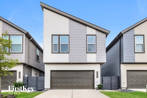 A modern two-story house with a garage is showcased.