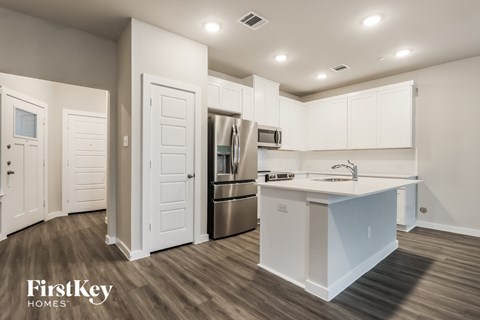 A kitchen with white cabinets and a stainless steel refrigerator.