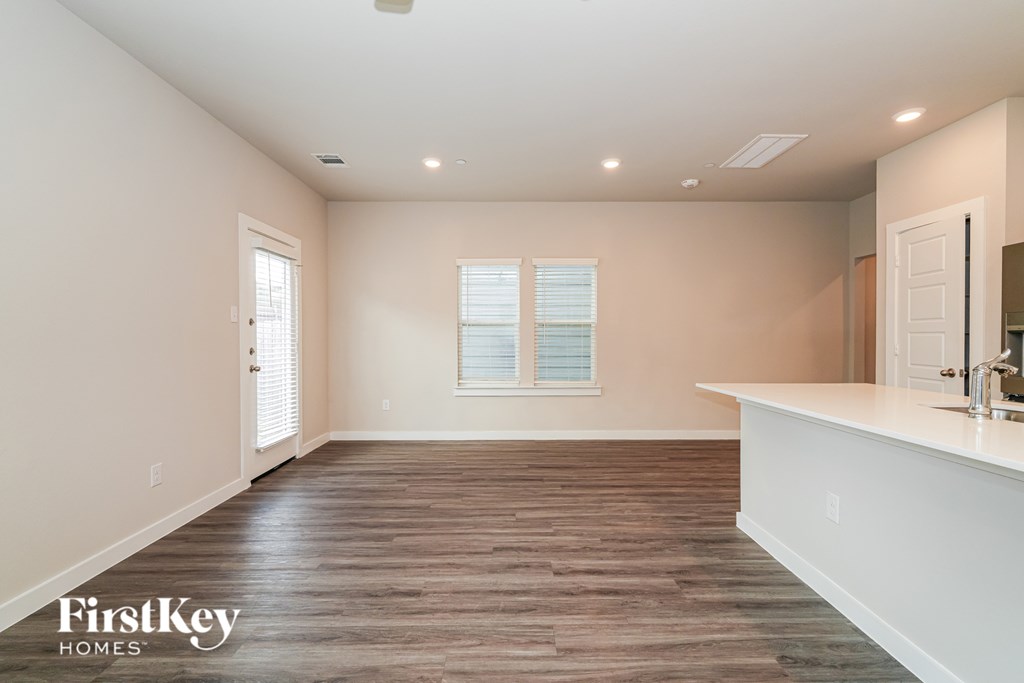 A spacious room with wooden flooring and a white countertop.