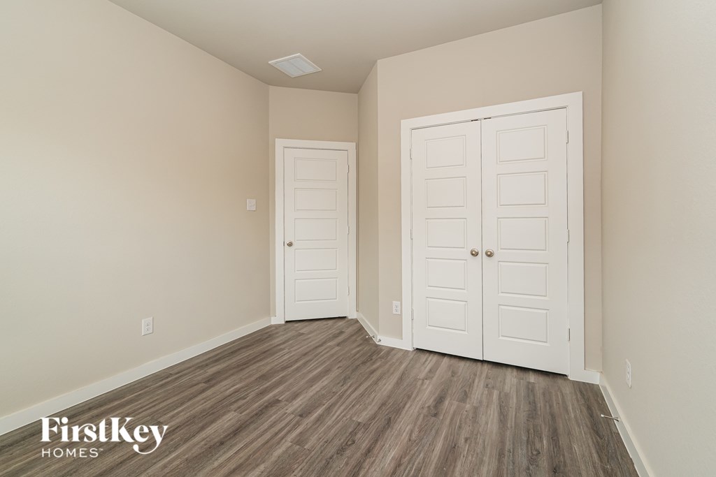 A room with two doors and wooden floors.