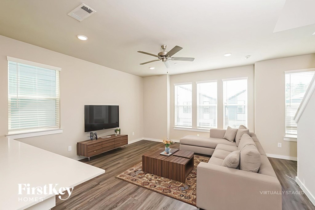 A spacious living room with a television and a couch.