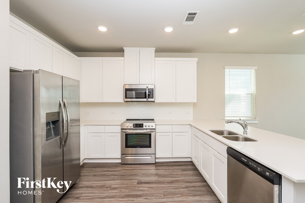 A kitchen with a stainless steel refrigerator, microwave, oven, and dishwasher.