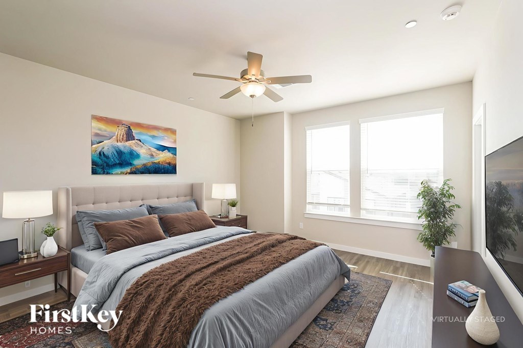 A bedroom with a large bed and a painting on the wall.