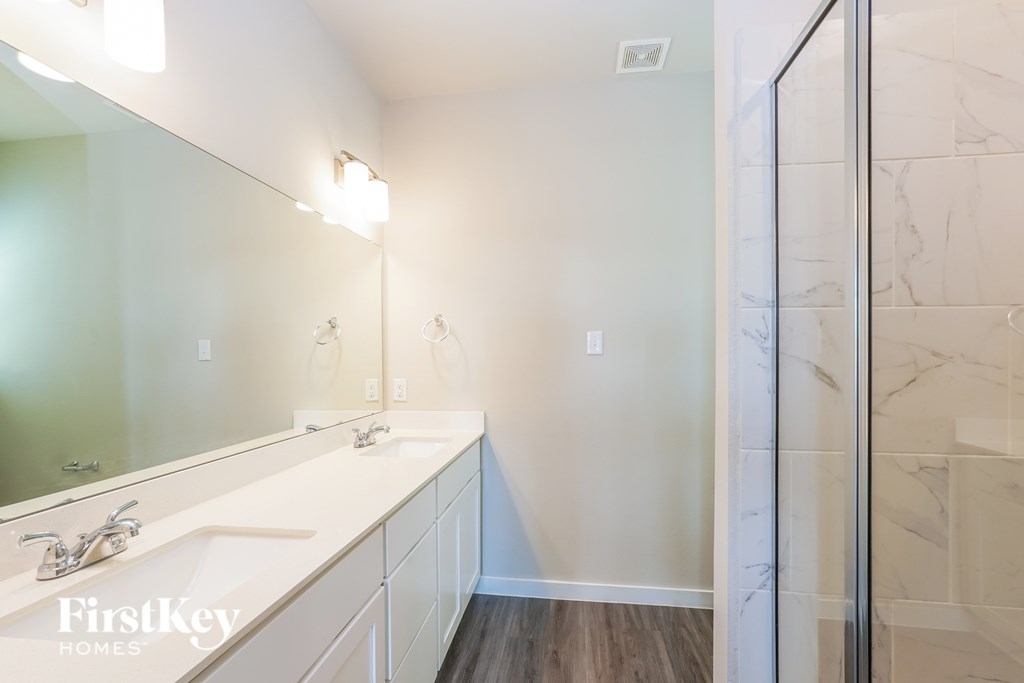 A bathroom with a marble wall and a large mirror.