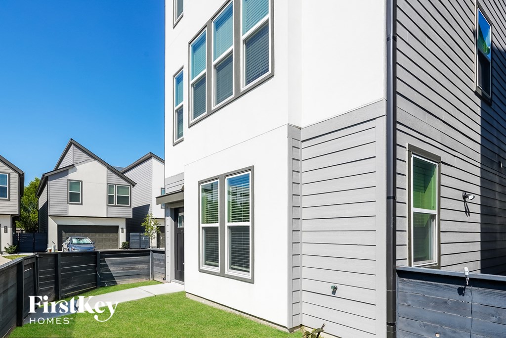 A modern house with a grey siding exterior and a white garage door.