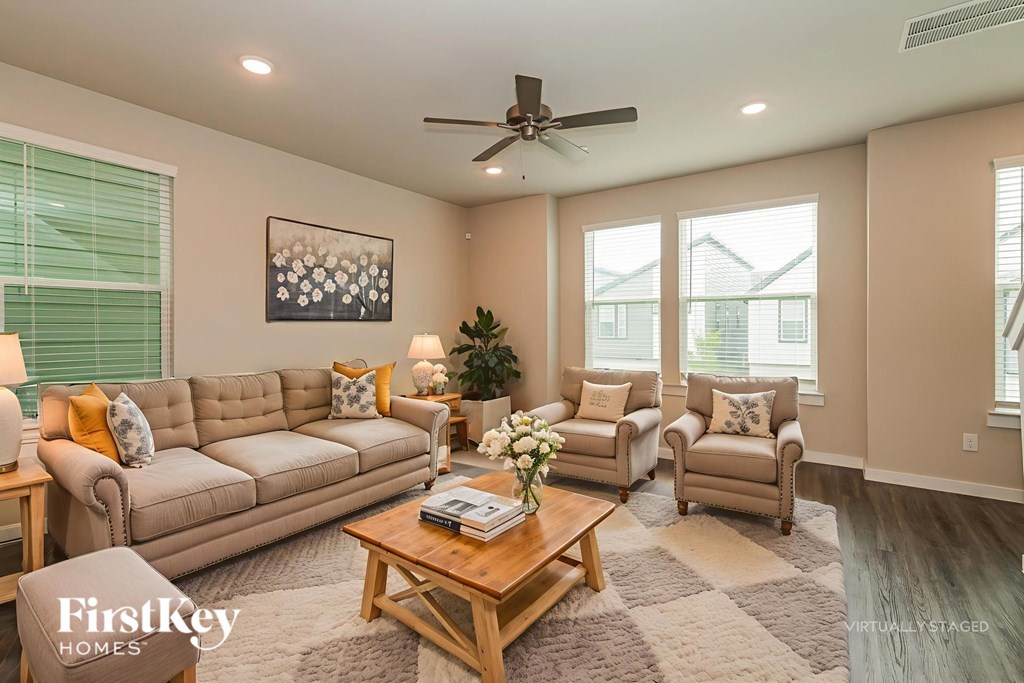 A living room with a beige sofa, two armchairs, and a coffee table.