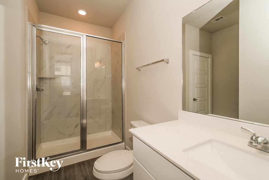 A white bathroom with a FirstKey Homes logo.