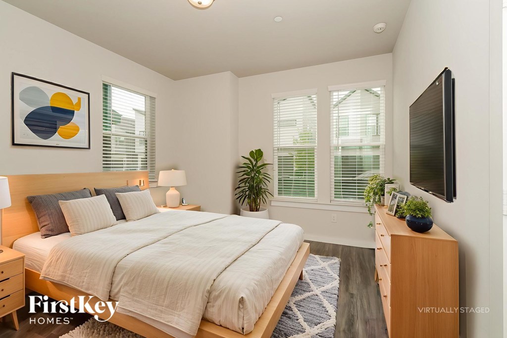 A bedroom with a bed, nightstand, and a television.