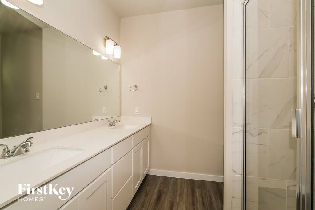 A bathroom with a white sink and a mirror.