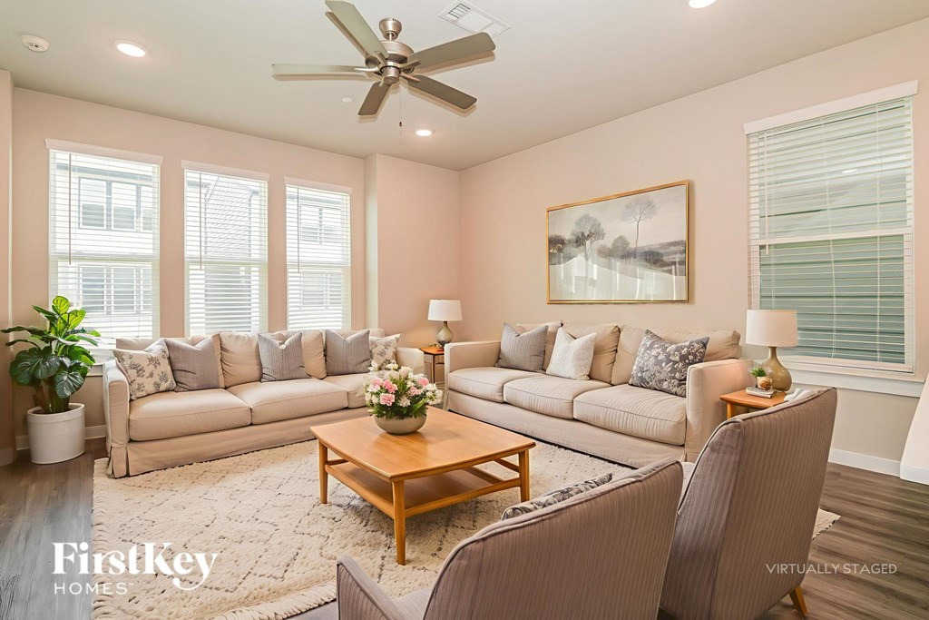 A living room with a large sectional sofa, a coffee table, and a painting on the wall.