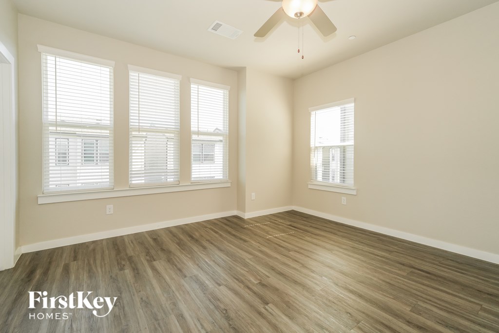 A room with wooden flooring and a ceiling fan.