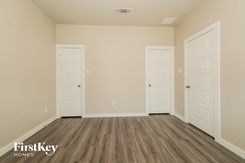 Three white doors in a room with wooden floors and a FirstKey Homes logo.