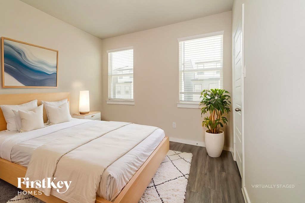 A bedroom with a large bed and a painting on the wall.