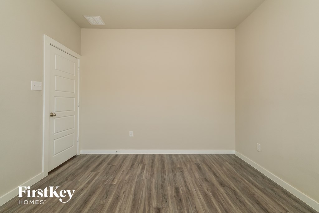 A room with wooden flooring and a white door.