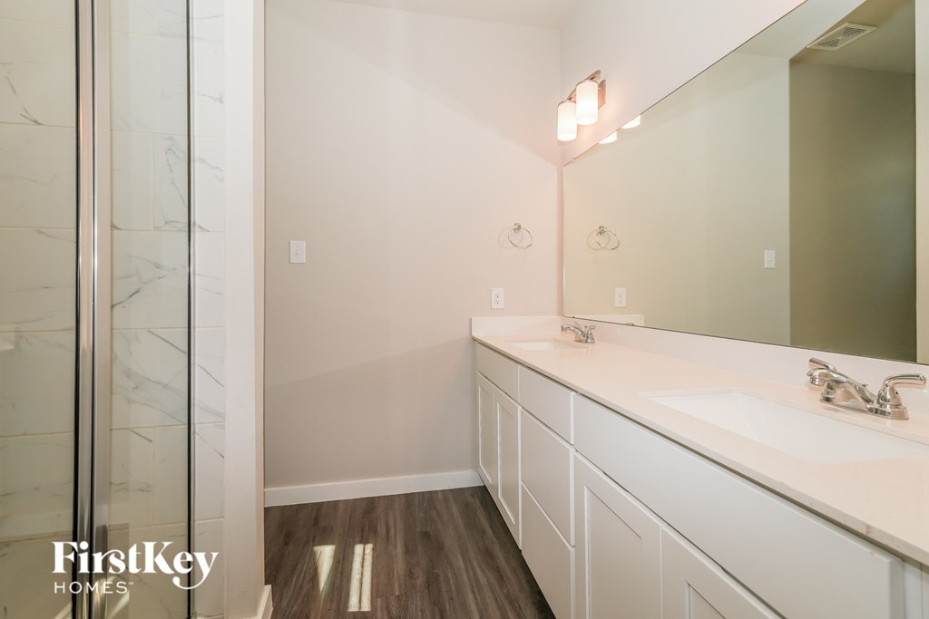 A bathroom with a marble wall and white countertops.