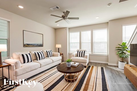 A living room with a white sofa, a coffee table, and a painting on the wall.
